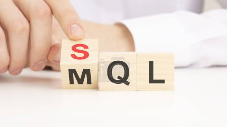 Símbolo SQL o MQL. Empresario se convierte en cubos y cambia las palabras 'MQL marketing lead calificado' a 'SQL sales qualified lead'.