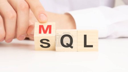 MQL or SQL symbol. Businessman turns cubes and changes words 'MQL marketing qualified lead' to 'SQL sales qualified lead'.