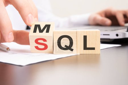 MQL or SQL symbol. Businessman turns cubes and changes words 'MQL marketing qualified lead' to 'SQL sales qualified lead'.