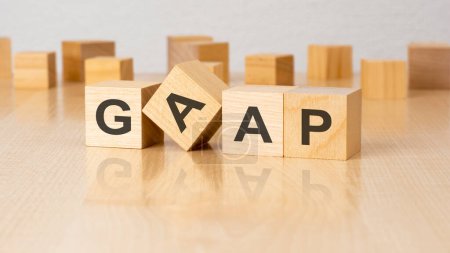 four wooden blocks with text GAAP on table. copy space. white background