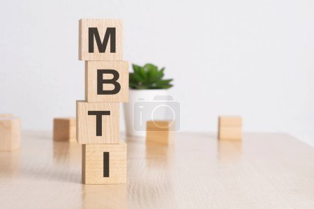 word MBTI with wood cubes, flower in a pot on white background