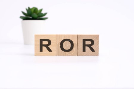 ROR - rate of return - acronym on wooden cubes on white background