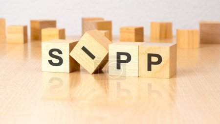 four wooden blocks with text SIPP on table. copy space. white background
