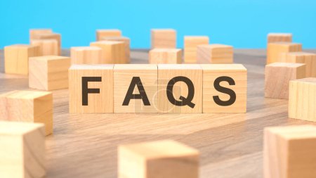 Foto de Faqs - palabra está escrita en bloques de madera. fondo azul. FAQS - abreviatura de Preguntas Frecuentes. - Imagen libre de derechos