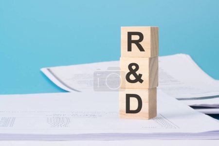 Holzwürfel mit Text R und D - Forschung und Entwicklung - auf Geschäftsdokument.