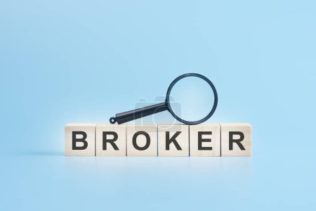 wooden blocks with a magnifying glass text: BROKER. blue background