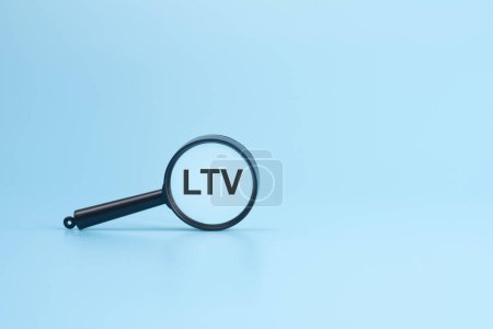 LTV text on magnifier on blue background, business concept