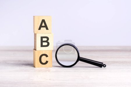 ABC - siempre estar cerrando - bloques de cubo de madera texto y lupa en la mesa. concepto de negocio.