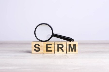 lupa y bloques de madera con el texto: SERM - Search Engine Reputation Management. puede ser utilizado para negocios, comercialización y concepto de educación