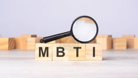 magnifying glass and wooden blocks with the text: MBTI. can be used for business, marketing and education concept