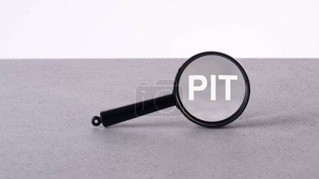 PIT text through a magnifying glass written on a light background.