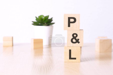 PL - Gewinn und Verlust - Text auf Holzwürfeln auf weißem Hintergrund.