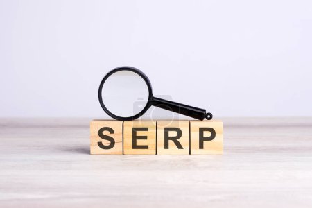 Lupe und Holzbausteine mit dem Text: SERP. kann für Geschäfts-, Marketing- und Bildungskonzepte verwendet werden