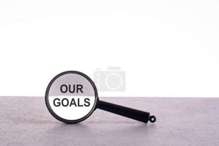 OUR GOALS text through a magnifying glass written on a light background.