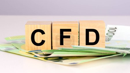 CFD - abréviation de Contrats pour Différence. texte sur les cubes de bois avec billets en euros. vue de face