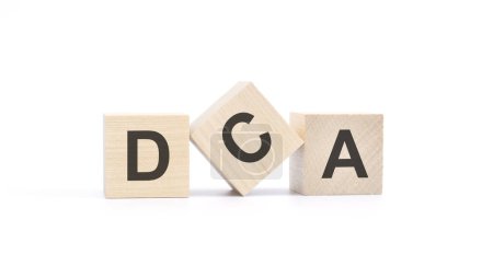 word DCA made with wood building blocks, white background.