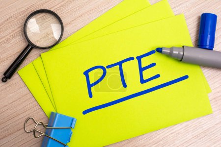 PTE - Pearson Tests of English - Akronym Textkonzept mit blauem Marker auf gelber Karte