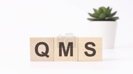 qms acronym on wooden cubes on white background. Quality Management System business concept