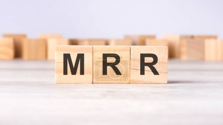 MRR - acronym concept written on wooden cubes or blocks on a light grey background