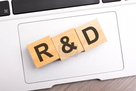 Holzblöcke mit den Buchstaben rd - Forschung und Entwicklung - auf Tastatur-Laptop