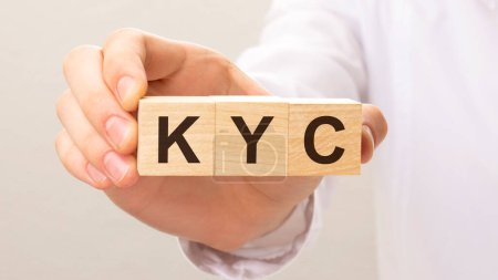 drei Holzwürfel mit den Buchstaben KYC auf der Hand auf weißem Hintergrund