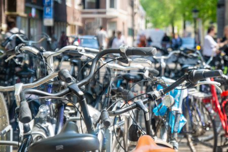 Téléchargez les photos : Paysage de transport hollandais typique. beaucoup de vélos garés dans une rangée sur un parking pour vélos dans une ville aux Pays-Bas, en Europe par une journée ensoleillée - en image libre de droit