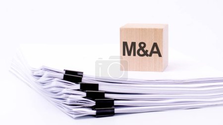 text ma - short for mergers and acquisitions - letters on wooden cubes on a white background