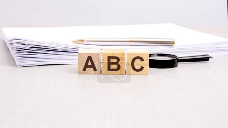 texto ABC escrito en los cubos de madera en letras negras, los cubos se encuentran en una superficie blanca.