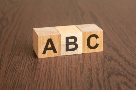 ABC - Siempre estar cerrando - acrónimo en cubos de madera sobre fondo de madera oscura