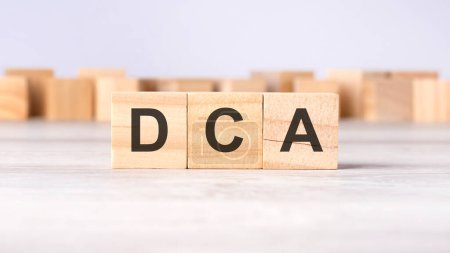 DCA - Akronym-Konzept auf Holzwürfeln oder -blöcken auf hellgrauem Hintergrund