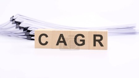 Holzwürfel mit Text CAGR auf weißem Tisch