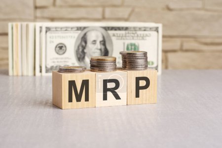 Palabra MRP sobre cubos de madera y billetes de dólar de fondo. Concepto de planificación de investigación