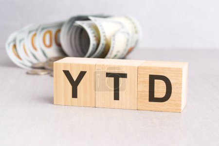Wort YTD auf Holzwürfeln, grauer Hintergrund, Geschäftskonzept