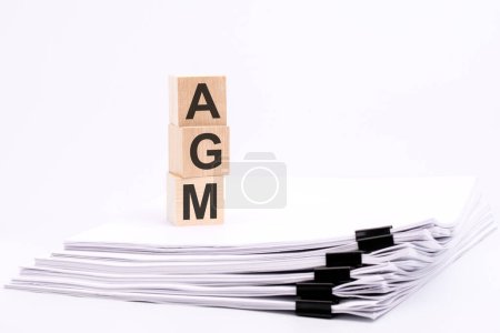 Holzwürfel mit Text AGM auf weißem Tisch