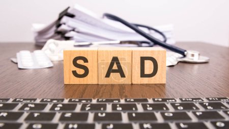 Photo for SAD - short for SEASONAL AFFECTIVE DISORDER - text on wooden cubes, medical concept - Royalty Free Image