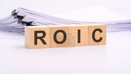 wooden cubes with text ROIC on white table