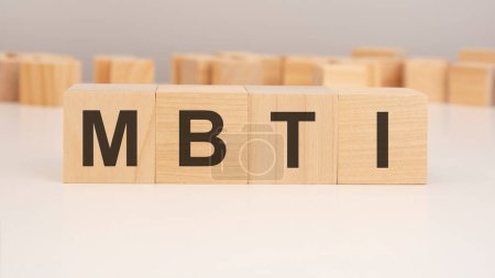 short word english letters with text - MBTI - on a small wooden cubes with white background. copy space concept. selection focus.
