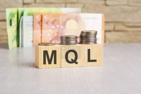 monedas y cubos de madera con texto: MQL o concepto de plomo calificado de marketing. espacio de copia