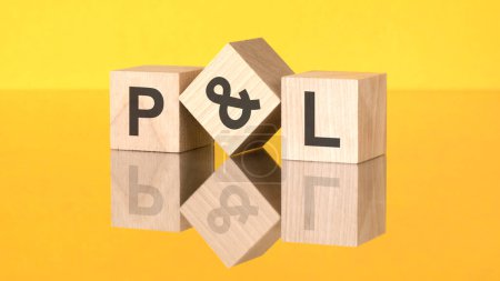 three wooden cubes with acronym P and L on yellow background. reflection of an image on a glass surface concept