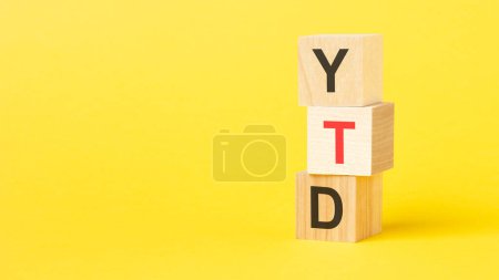wooden cubes with text YTD. yellow background