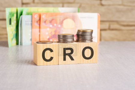 money and wooden cubes with text: CRO or Conversion Rate Optimization concept. copy space