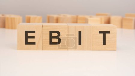 short word english letters with text - EBIT - on a small wooden cubes with white background. copy space concept. selection focus