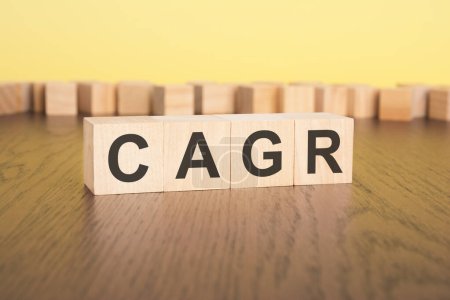 Photo for Short word english letters with text - CAGR - on a small wooden blocks. brown background. selection focus. - Royalty Free Image