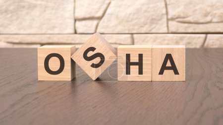 Téléchargez les photos : Mot OSHA cube bois sur fond de table en bois. concept d'entreprise - en image libre de droit