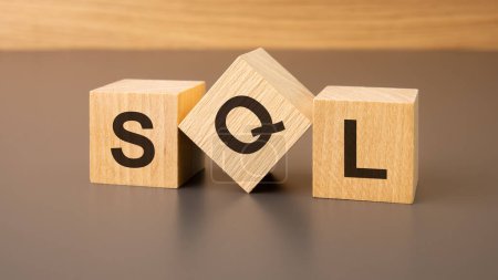 Wooden cubes on a brown background with the text 'SQL' represent the concept of 'Sales Qualified Lead'. It visualizes the process of filtering identified potential customers ready for purchase.
