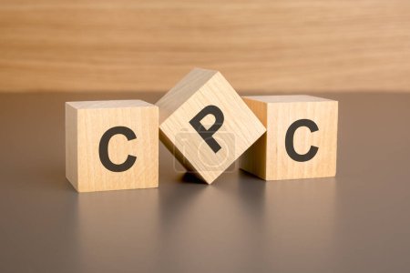 Holzwürfel auf braunem Hintergrund mit dem Schriftzug "CPC" repräsentieren das Konzept "Cost Per Click". Zahlungssystem in der Online-Werbung, bei dem die Ausgaben von der Anzahl der Klicks auf das Anzeigenmaterial abhängen