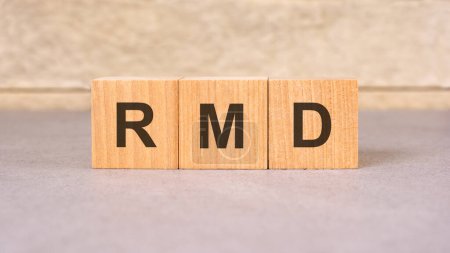 wooden block labeled RMD represents Required Minimum Distribution, a crucial aspect of retirement planning. It signals mandatory withdrawal from retirement accounts, emphasizing financial foresight.