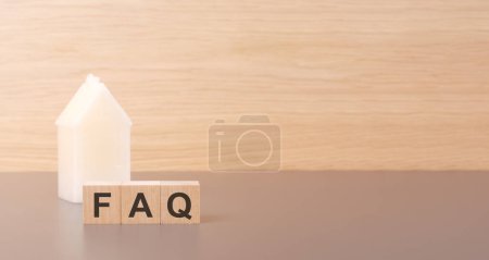 Photo for On a light background there is a row of cubes and a toy house in the background. finance and banking concept. Acronym faq of frequently asked questions - Royalty Free Image