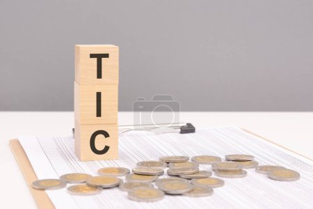 wooden blocks on a brown background with the text TIC - an abbreviation for Tenancy In Common. strong business concept