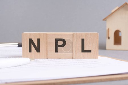 Photo for Npl text made of wooden cubes on gray background with a small wooden model house - Royalty Free Image